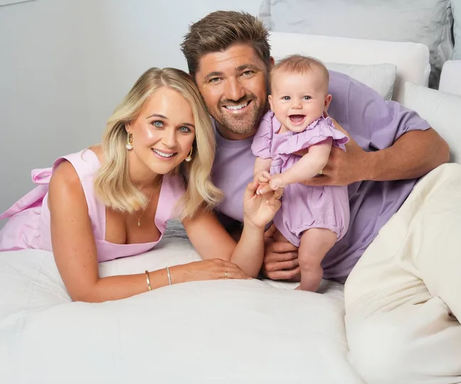 Couple and baby wearing purple
