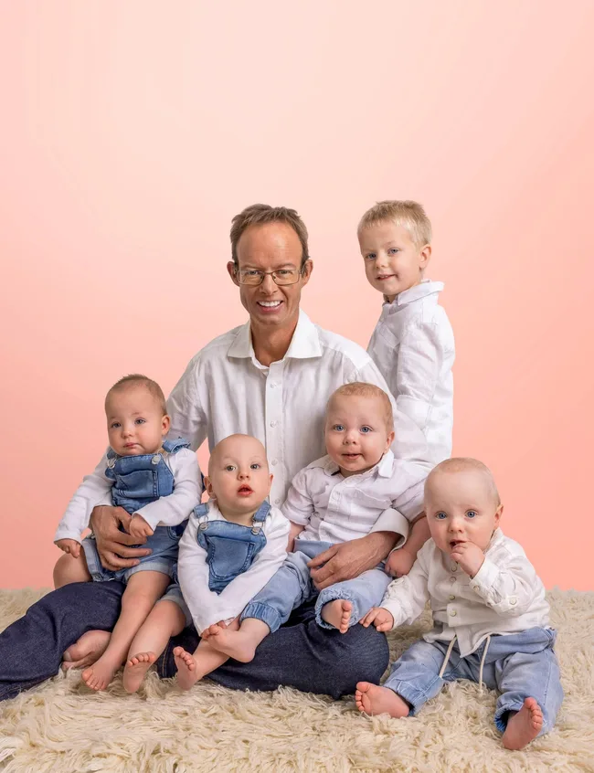 Dad with children and a pink background