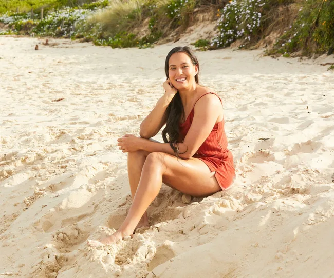 woman sitting on sand at a beach