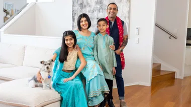 Kiwi-Indian family in bright living room sitting on couch