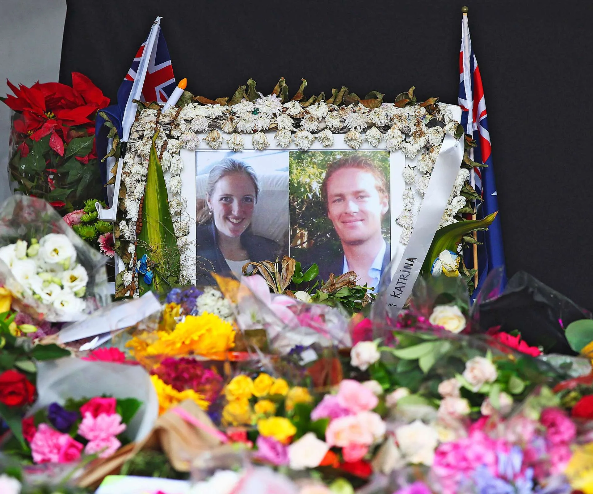 Memorial for a female and male. Flowers scatterd around the frame.