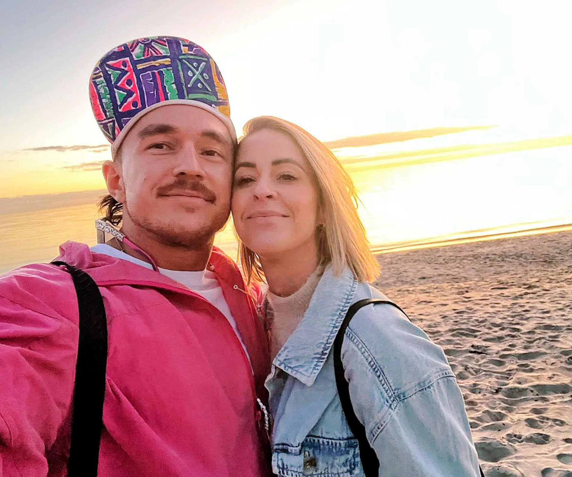 Couple taking selfie at a beach at sunset