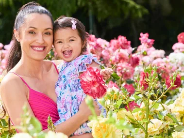 Tania Tapsell holding her daughter in a field of flowers