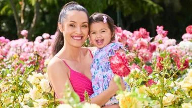 Tania Tapsell holding her daughter in a field of flowers