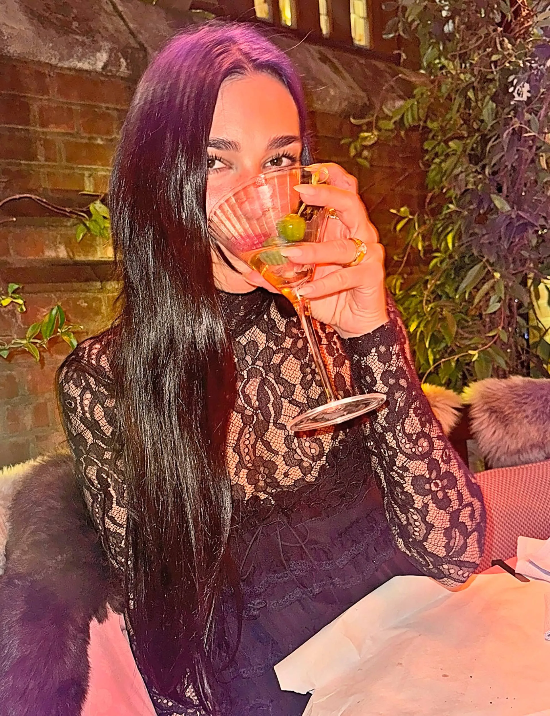 Dua Lipa drinking a martini