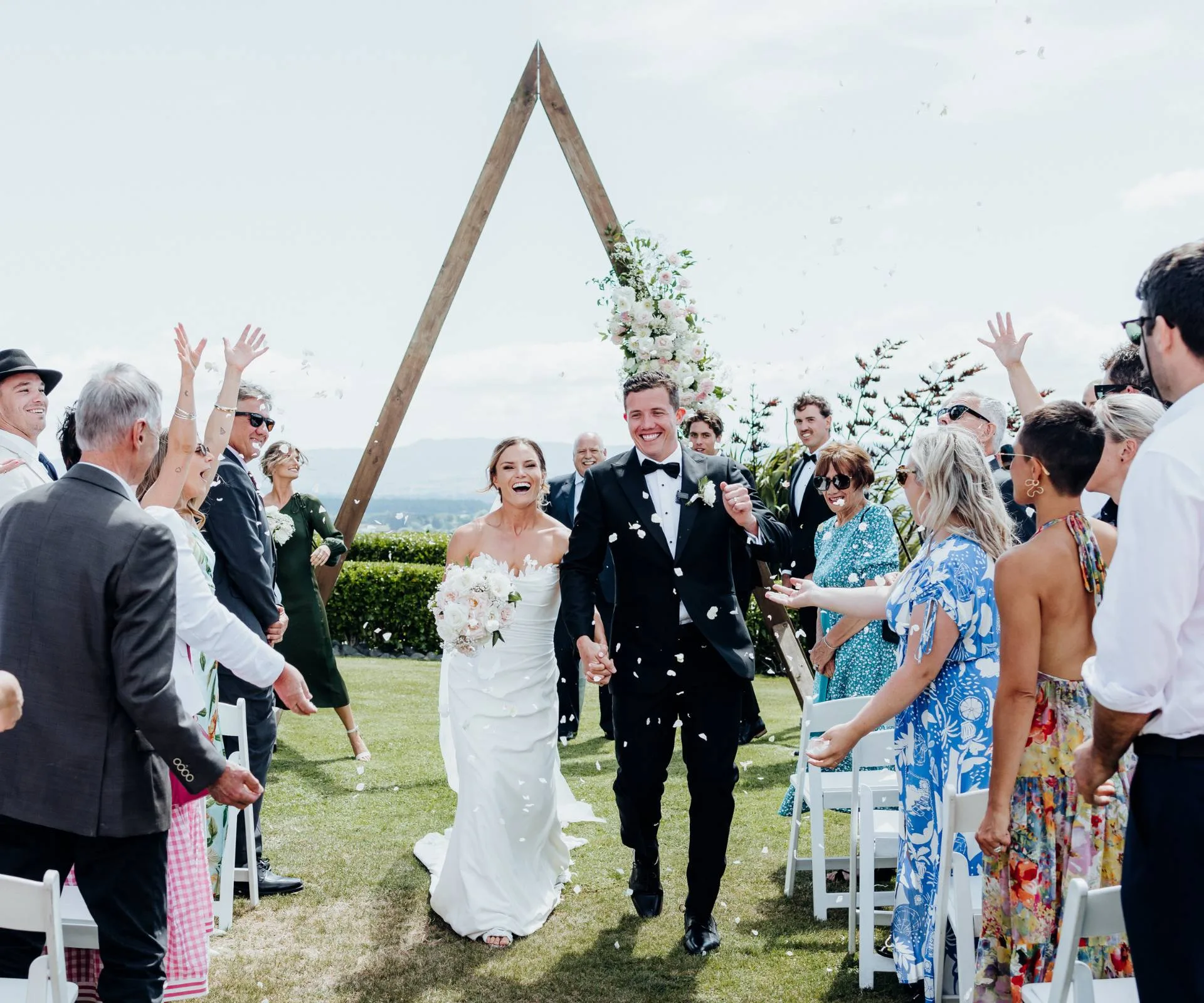 Michaela and Michael leaving their wedding ceremony in a shower of rose petals