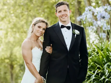 Michaela Blyde holding her new husband's hand on their wedding day