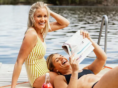 Two women sitting on a pontoon after swimming