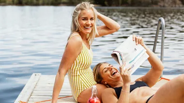 Two women sitting on a pontoon after swimming