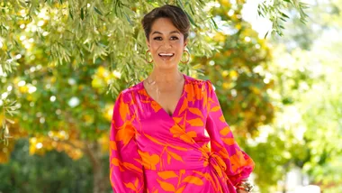 Teuila Blakely dancing outside in a red and orange dress