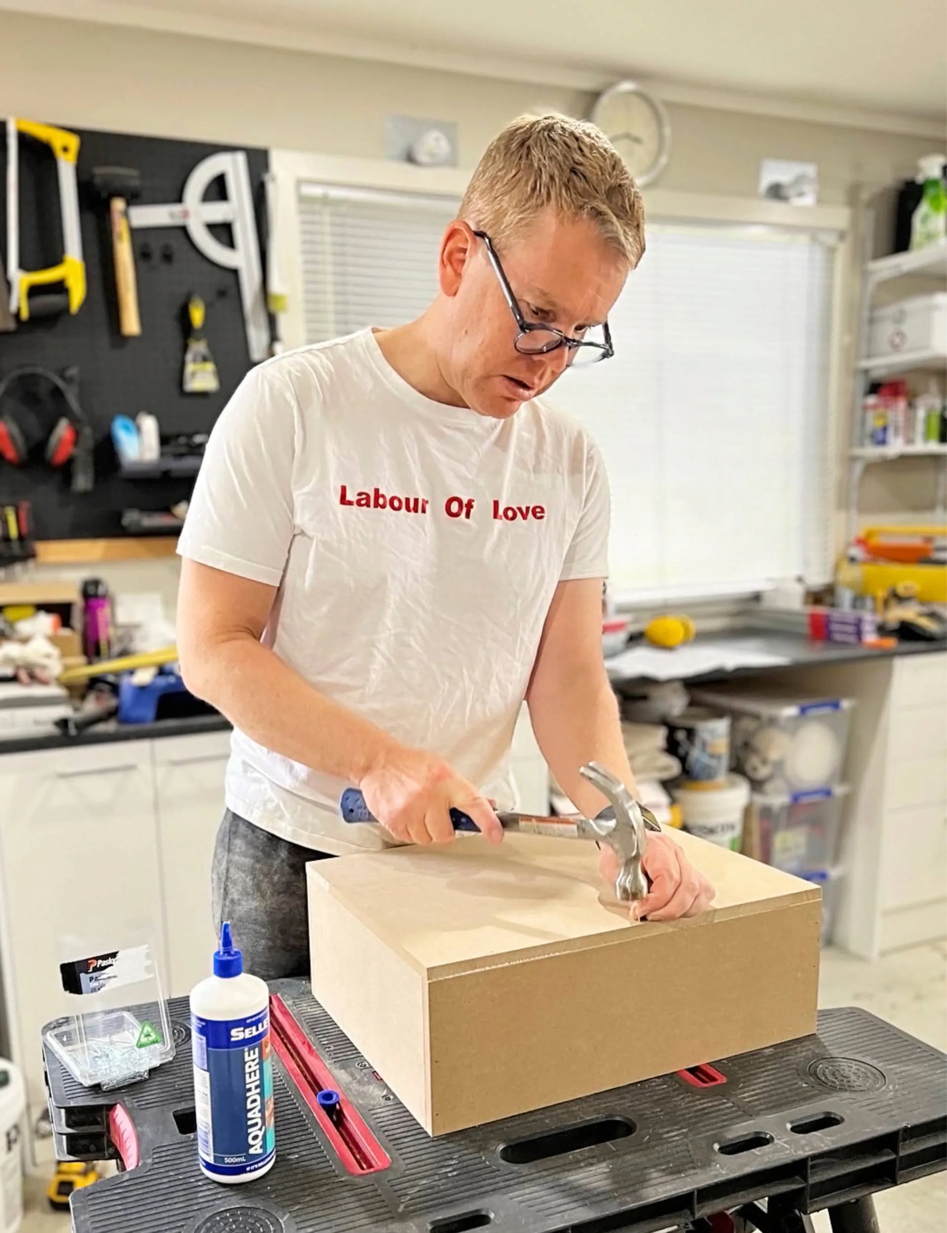 Chris Hipkins hammering a nail into a wooden box