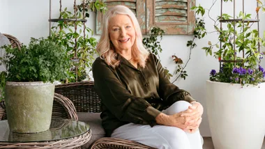 Robyn Martin sitting on a chair in front of potted indoor plants