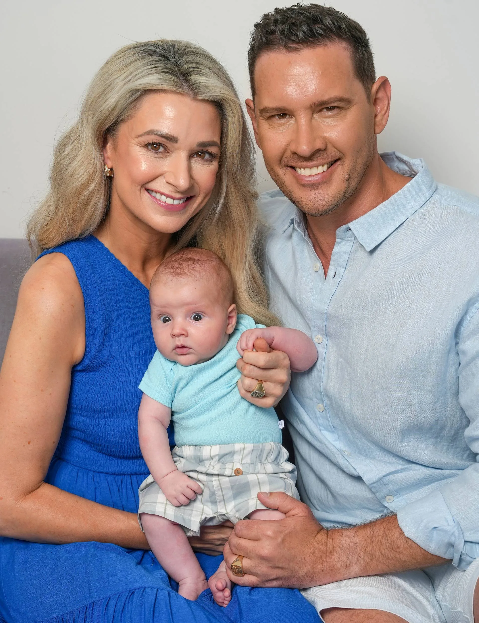 Zac and Erin holding baby Harley on a couch