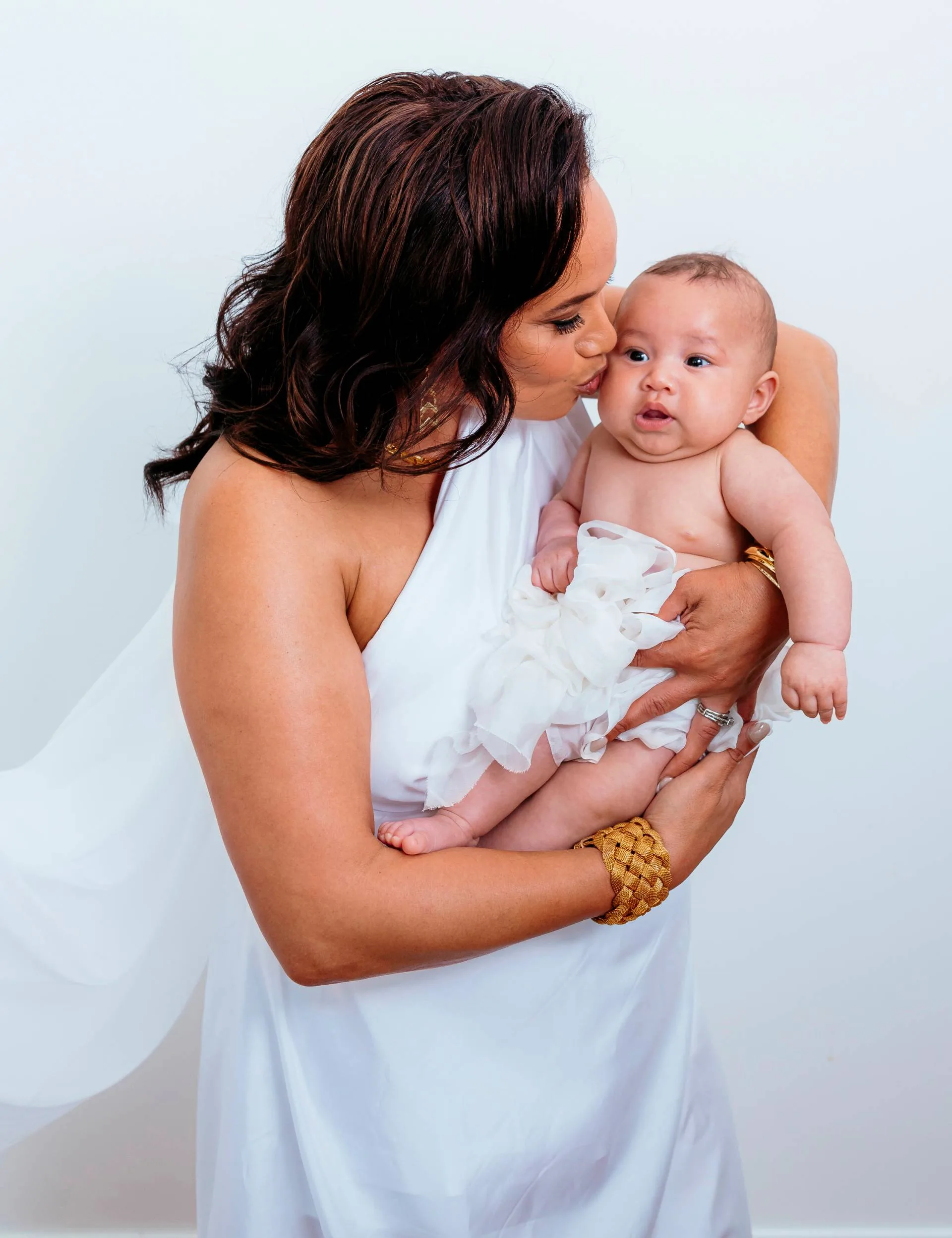 Megan Alatini cradling and kissing her granddaughter