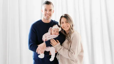 Scott with his family in front of white curtains