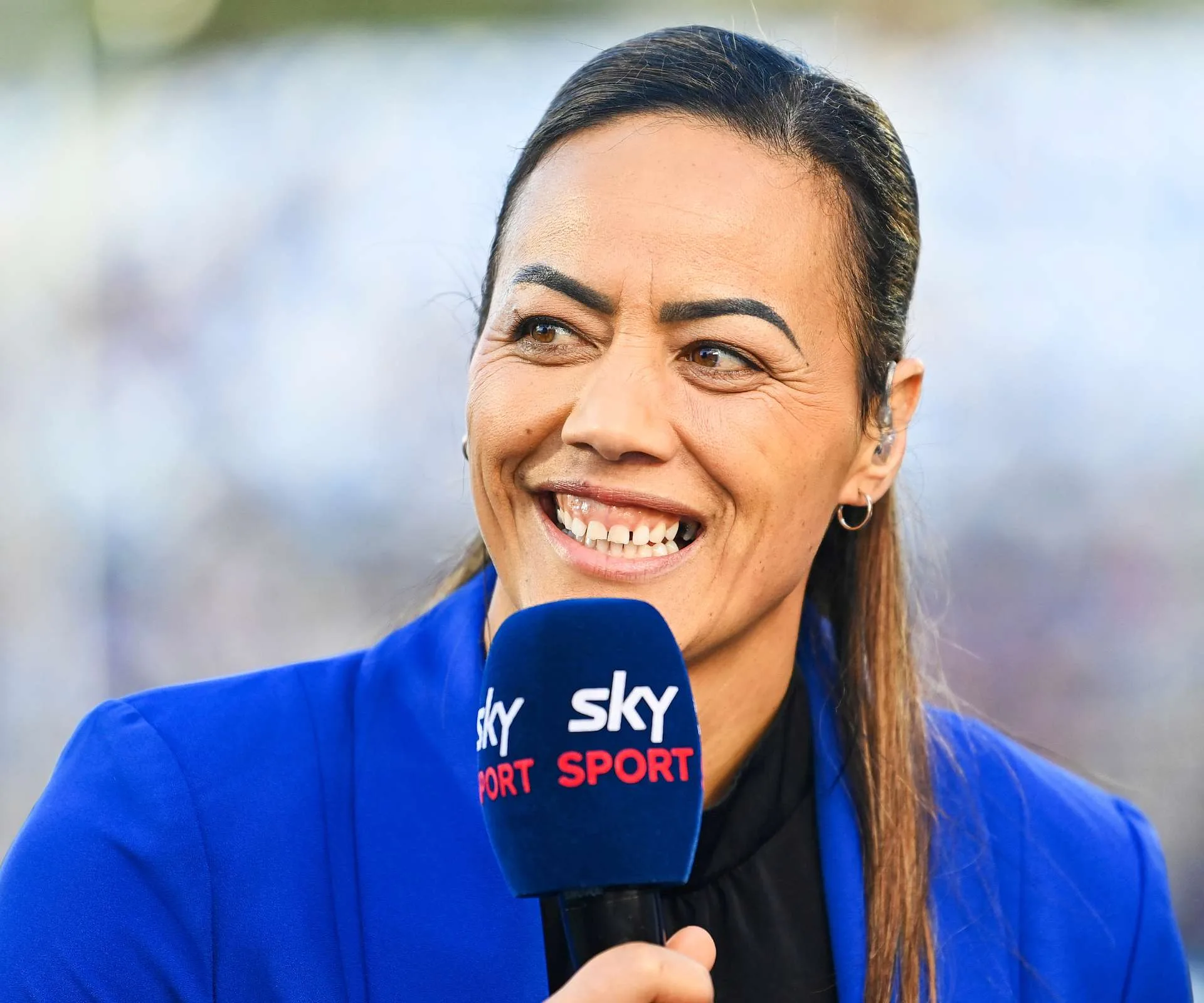 Honey Hireme-Smiler speaking into a Sky Sport microphone