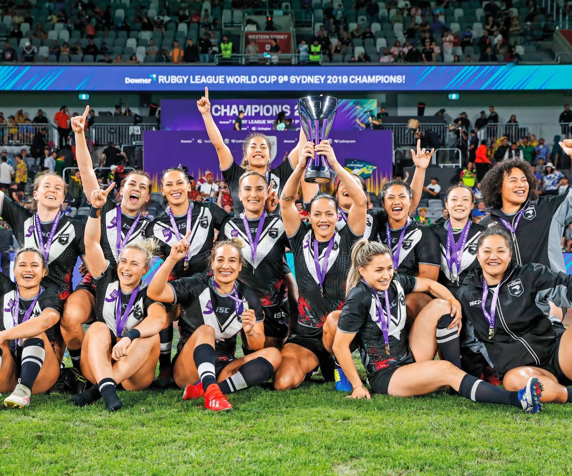 Rugby girls teaming winning trophy.