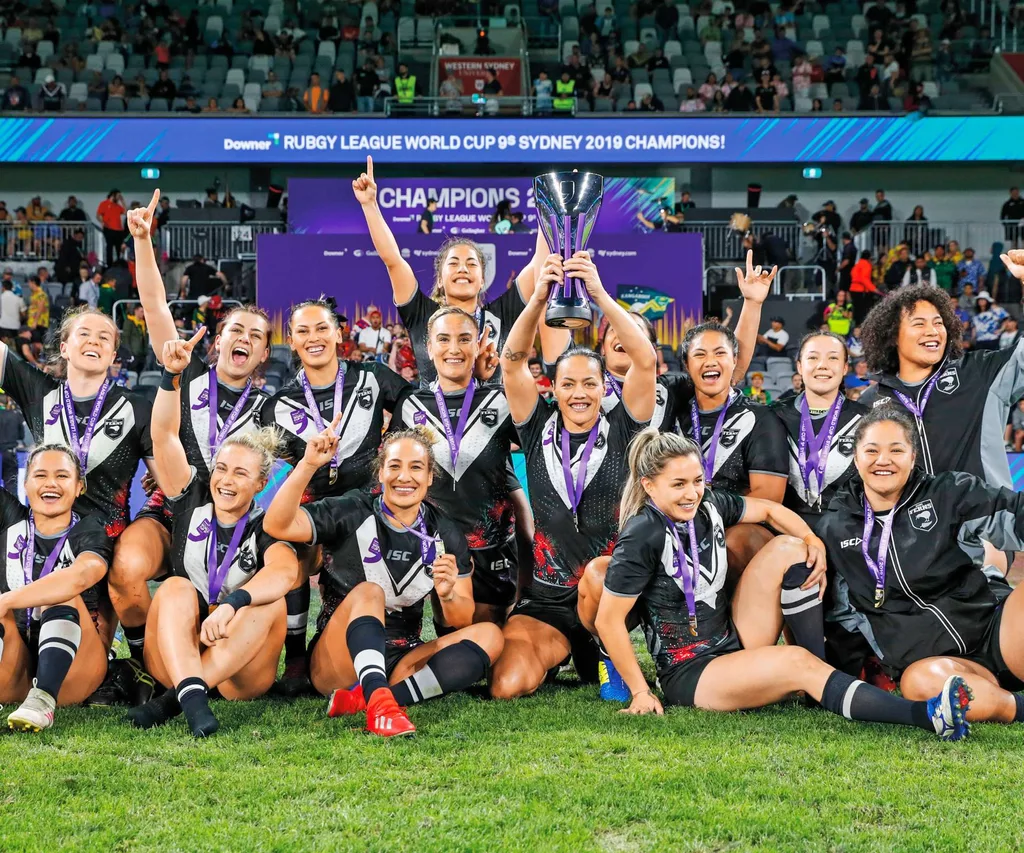 Rugby girls teaming winning trophy.