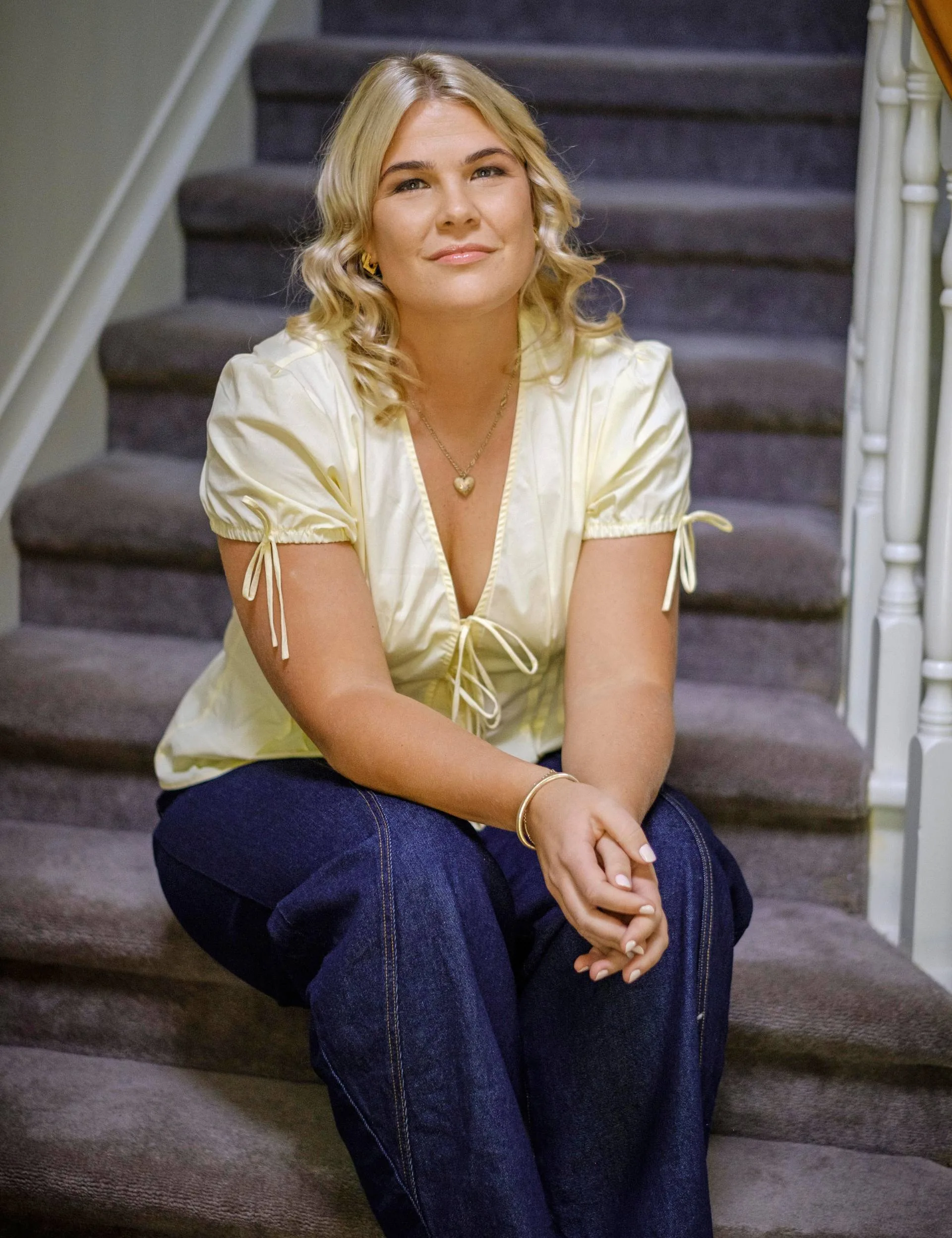 Young blonde woman sitting on stairs