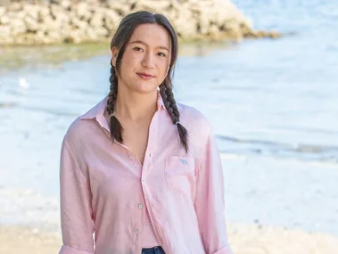 Girl with plaits standing on beach