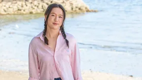 Girl with plaits standing on beach