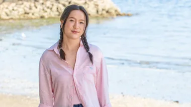 Girl with plaits standing on beach