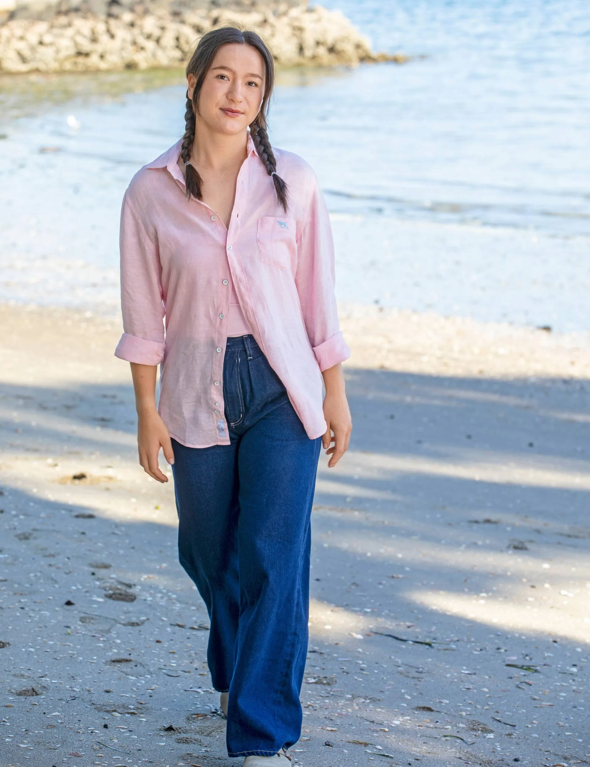 Girl with plaits on standing on a beach