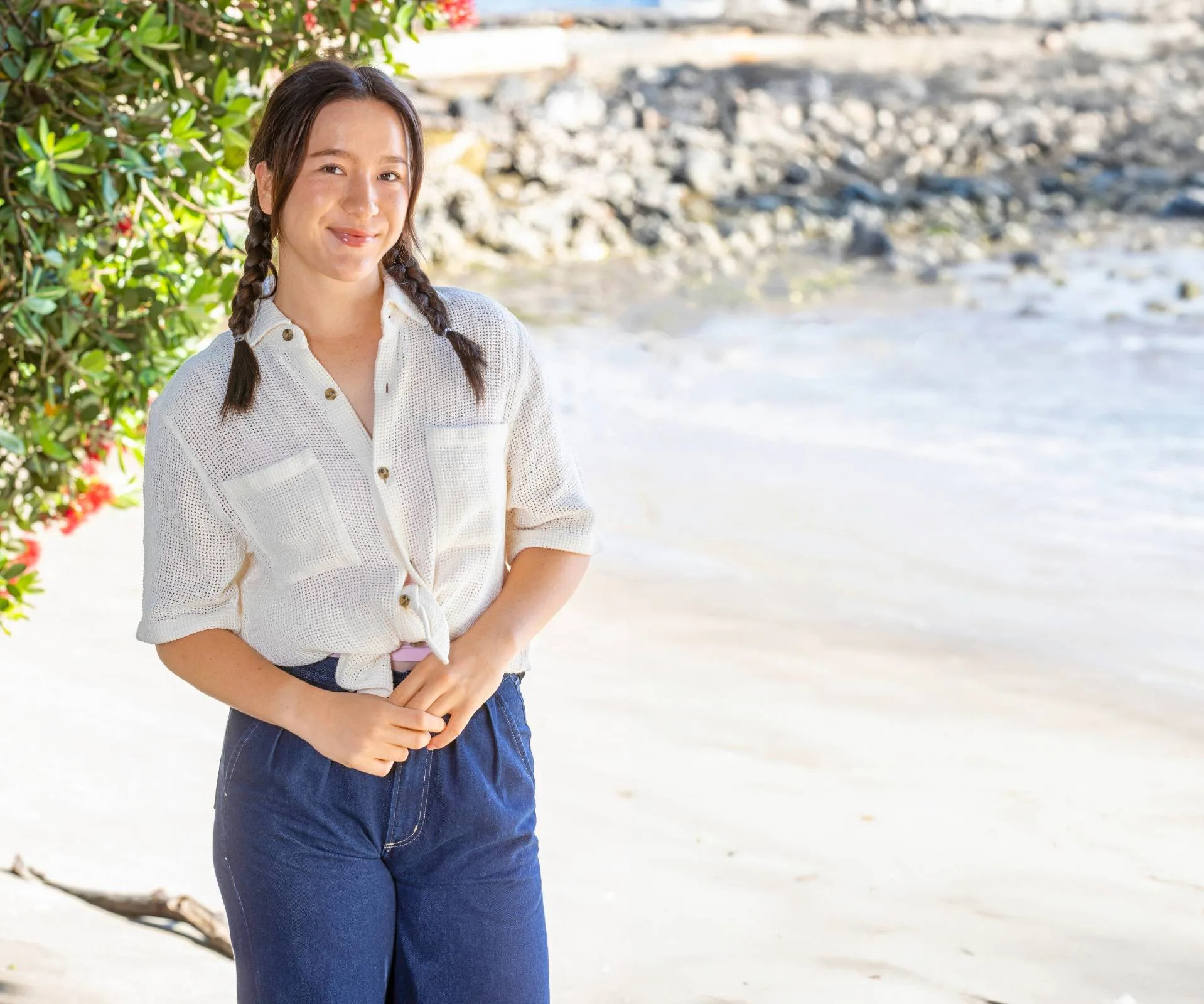 Girl with plaits on standing on a beach