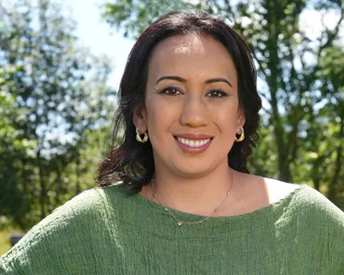 Lady with make-up and a greenn shirt, standing in a forrest