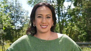 Lady with make-up and a greenn shirt, standing in a forrest