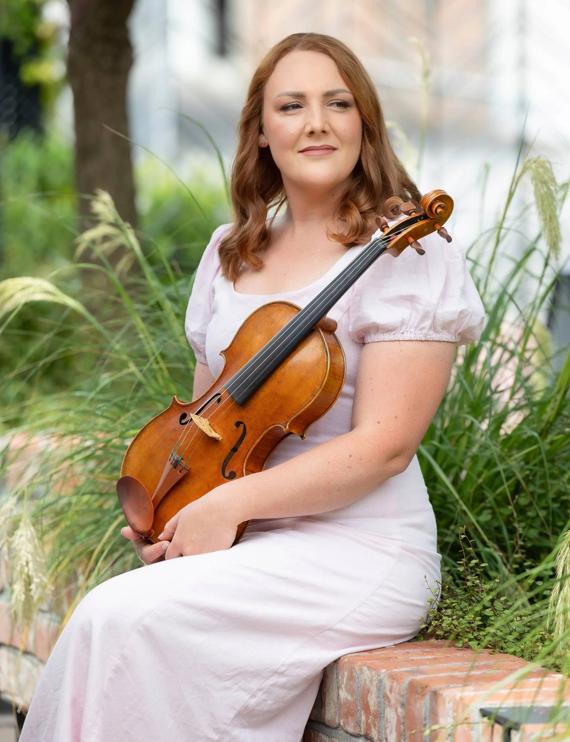 Alice Sip sitting outside with her viola