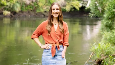 Nicole Murray in a midi denim skirt and orange top