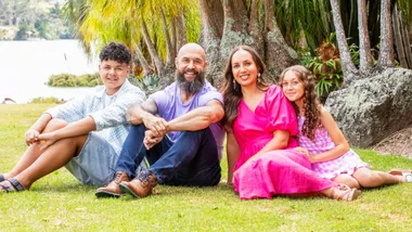 DJ Forbes sitting on some grass with his family