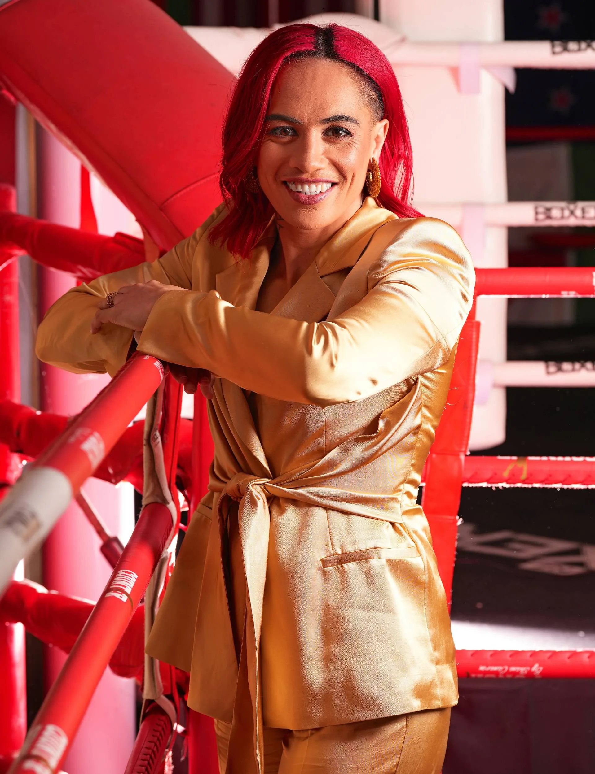 Mea Motu wearing a gold suit in the boxing ring