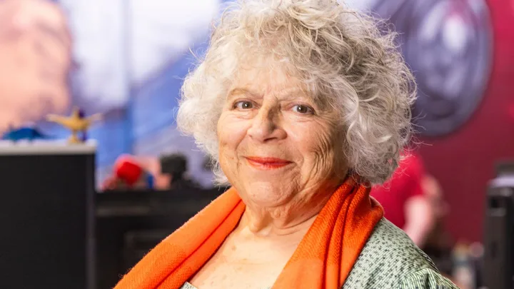 Miriam Margolyes smiling in an orange scarf