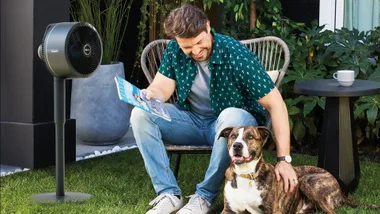 A man and his dog enjoying the Shark FlexBreeze Fan