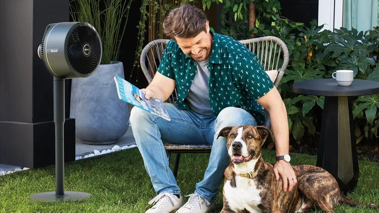 A man and his dog enjoying the Shark FlexBreeze Fan
