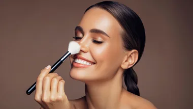 A model sniffing her clean makeup brushes