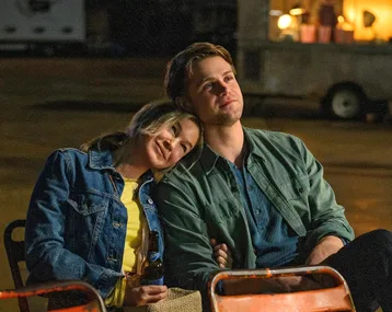 renee zellweger and leo woodall sitting side by side with her head on his shoulder