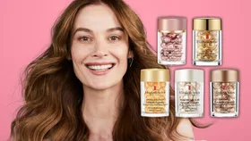 Women smiling with pink background with Elizabeth Arden Ceramide bottles