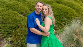 Tom Rutherford with his fiancée Hannah in front of the sand dunes at a beach