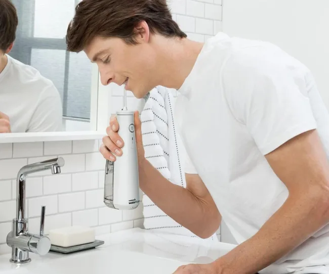 Man using the waterpik cordless select