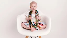 Indi Tunnage sitting on a chair wearing her cancer beads