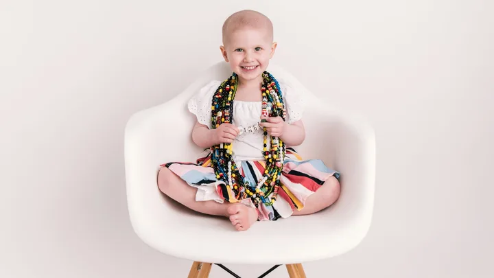 Indi Tunnage sitting on a chair wearing her cancer beads
