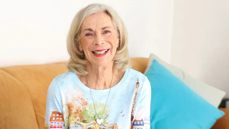 Katherine Switzer smiling on a brown leather couch