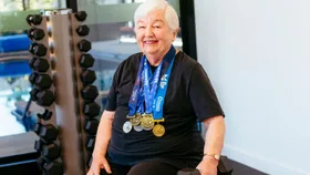 Avila Allsop sitting on a gym bench with a dumbbell in her hand