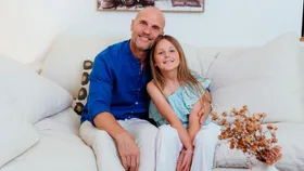Ben Barrington sitting on the couch with his daughter Harley