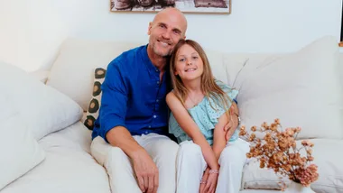Ben Barrington sitting on the couch with his daughter Harley