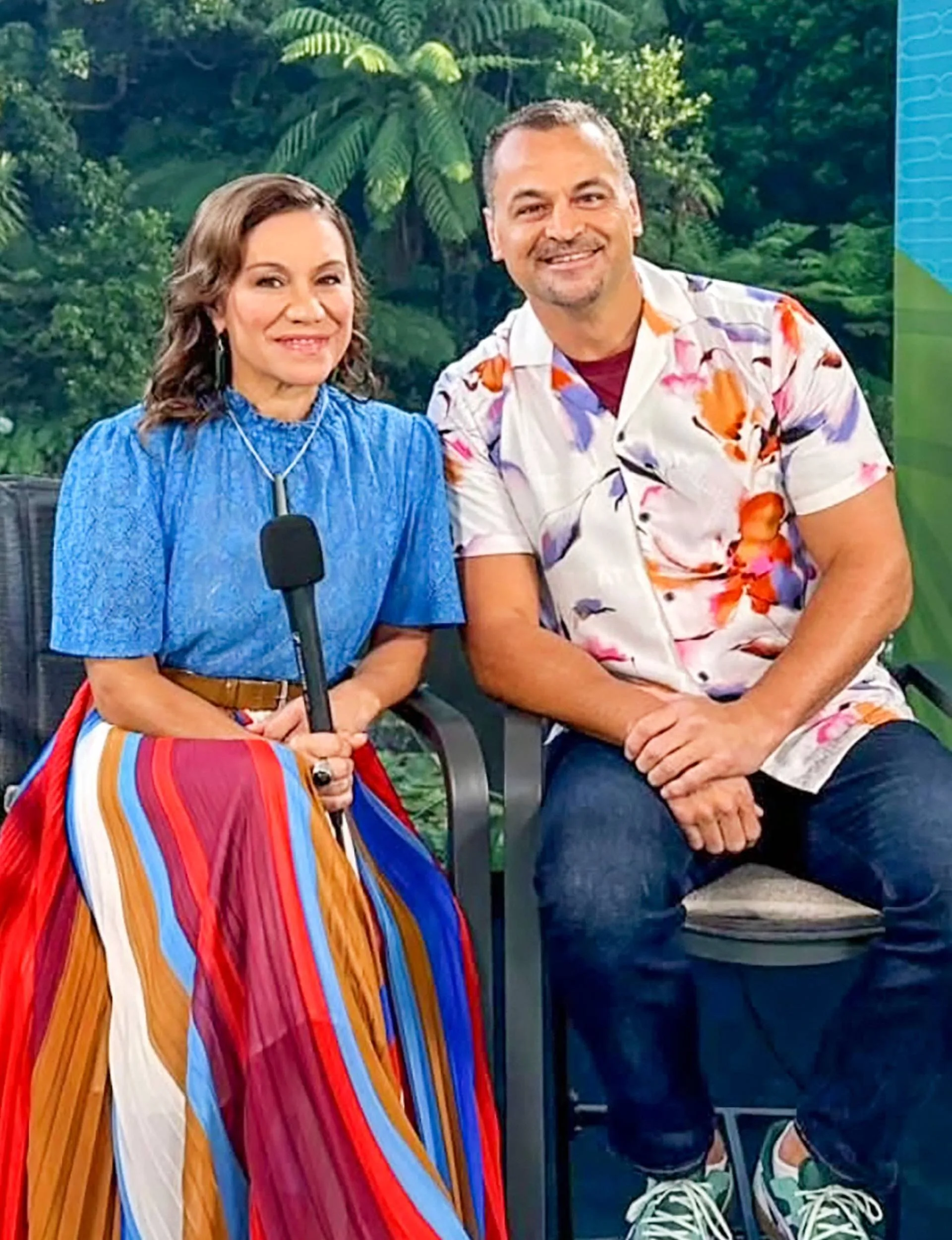 Stacey Morrison sitting on a tall stool beside husband Scotty