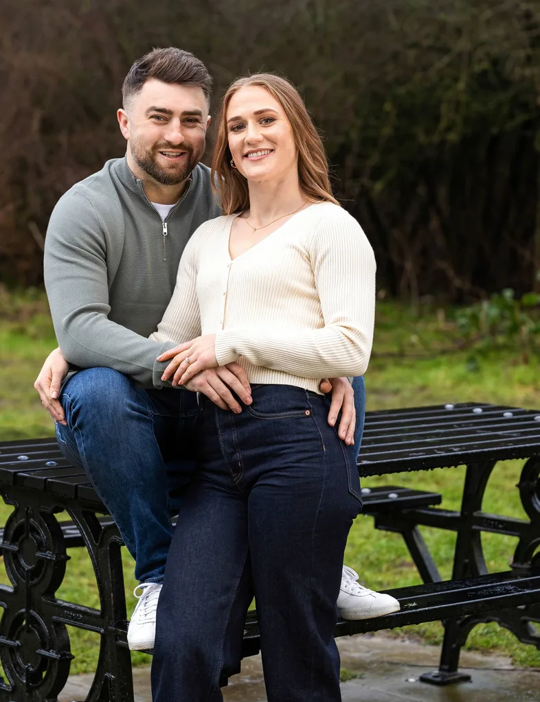 Man and woman sitting in park engaged